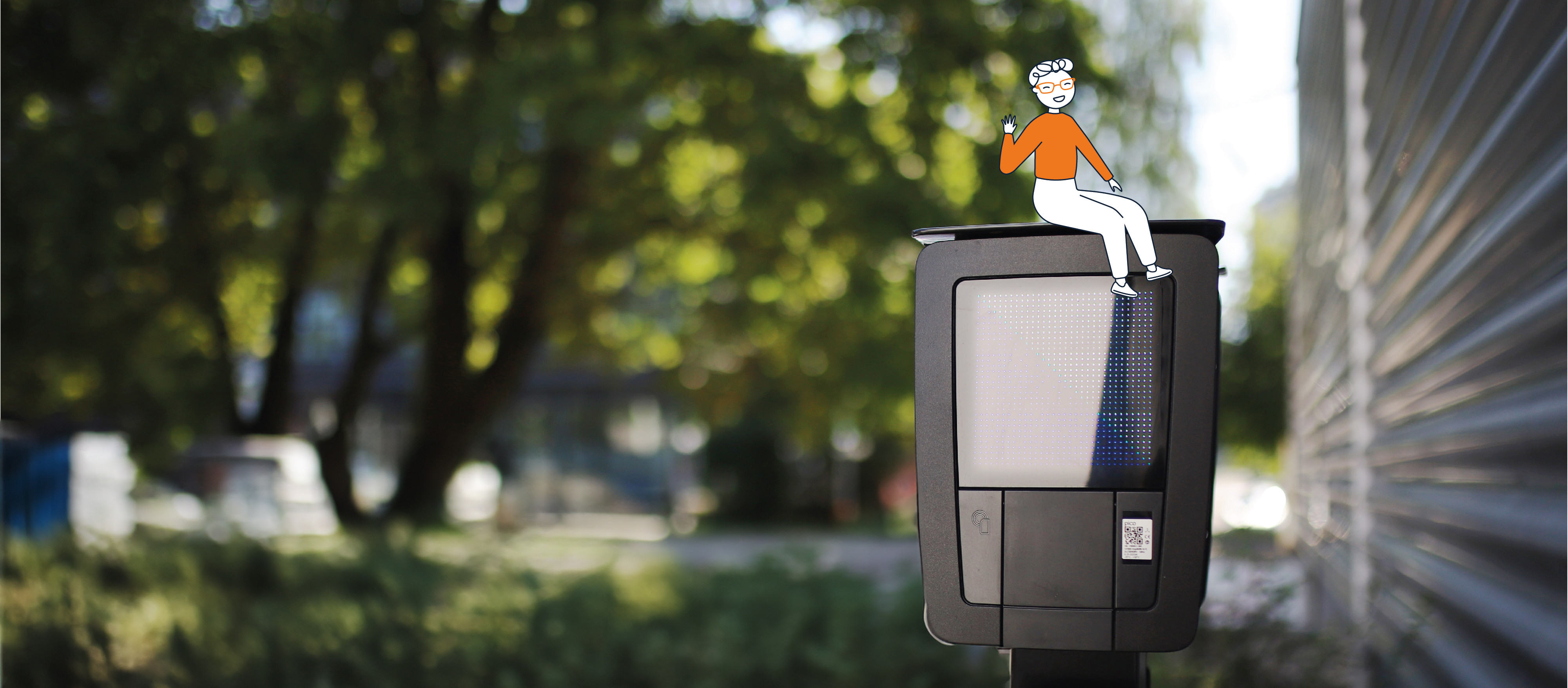 Un petit personnage habillé en orange assis sur une borne électrique.