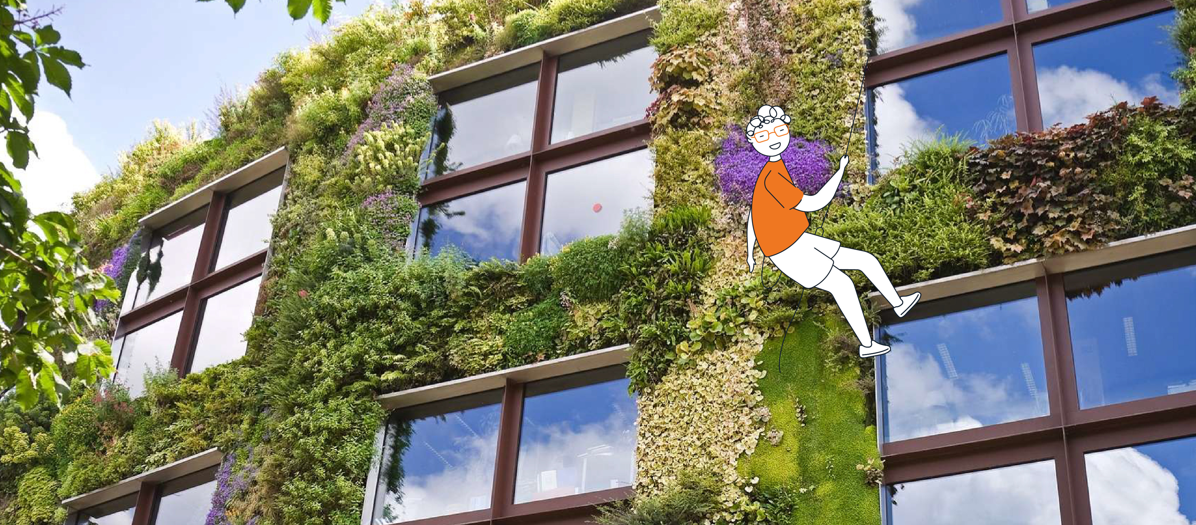 Un personnage habillé en orange déscendant en rappel d'une section de bâtiment recouvert de verdure.