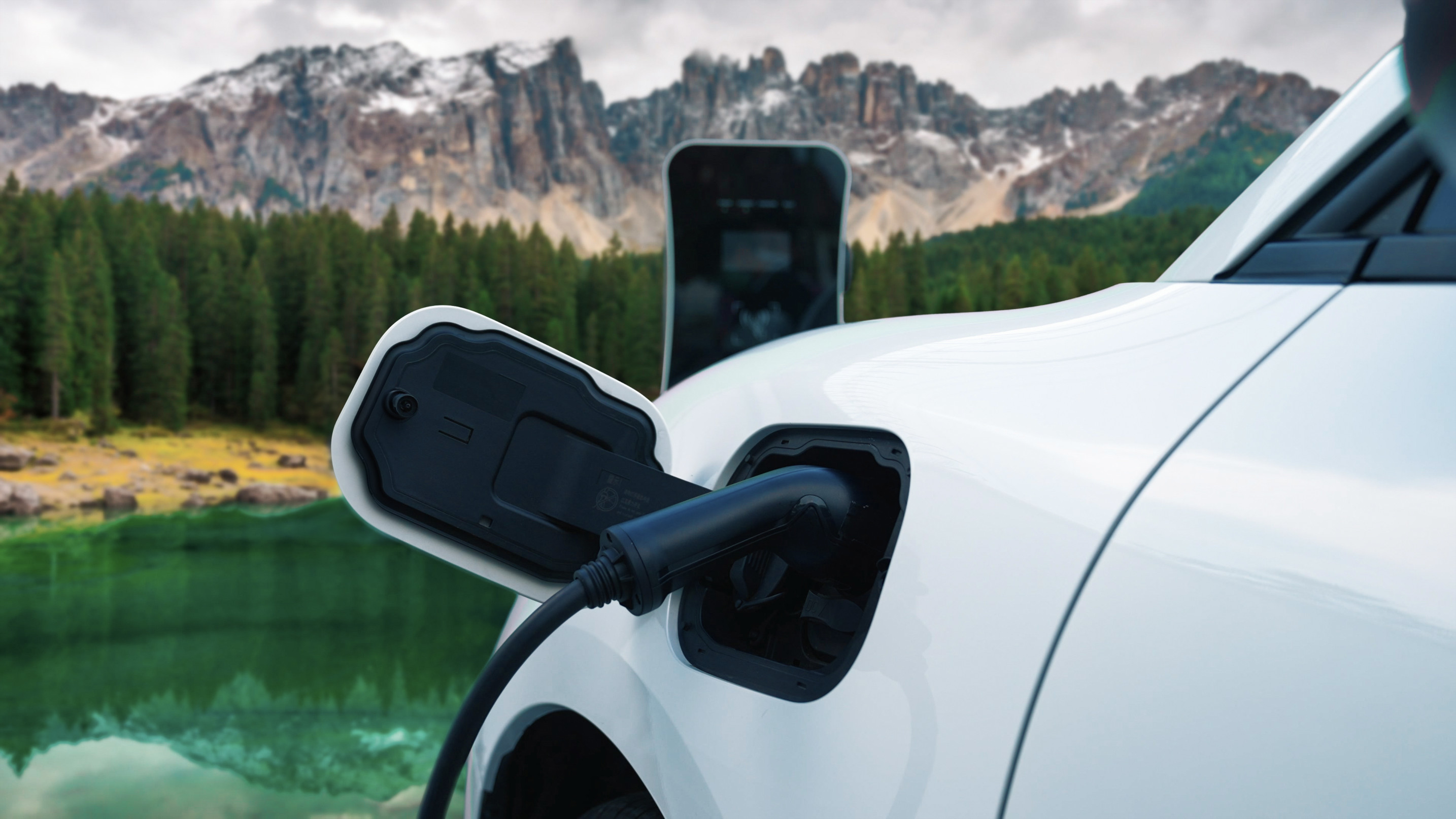 Une voiture électrique positionnée pour observer un lac bleu.